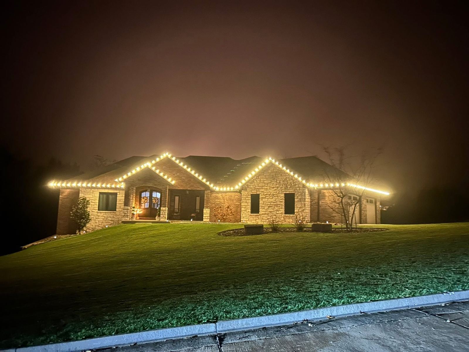 Ranch home outlined in warm white holiday lights